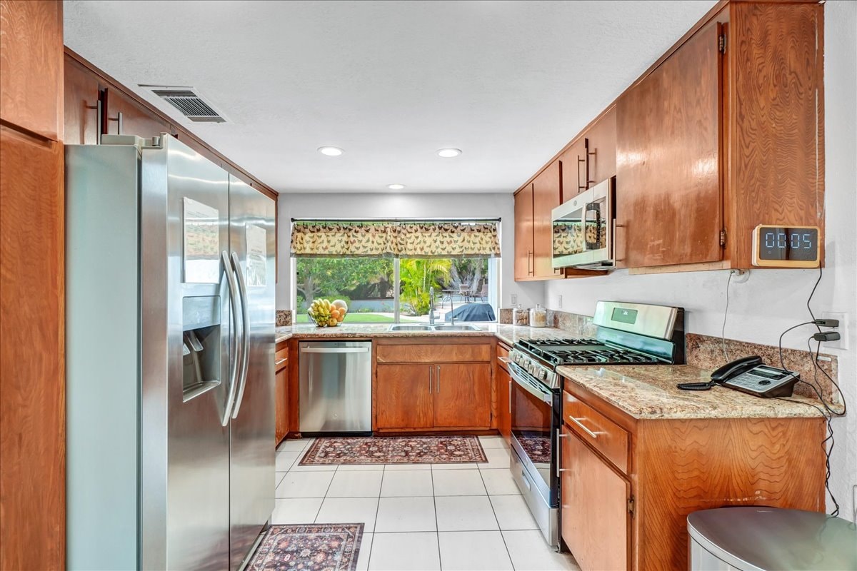 Kitchen with warm wood cabinets and stainless appliances at Blessings Senior Care East Orange View, Orange CA
